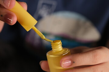 Naklejka premium woman opens nail polish cap