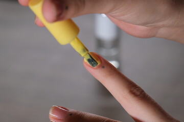 woman applying nail polish to her nails