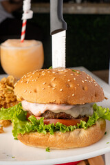 Hamburguesa artesanal hecha con torta de carne angus a la parrilla y deliciosa salsa, acompañada...