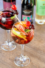 Sangría de frutos rojos vino rosado con decoración de cereza y uva con otra sangría detrás en fondo desenfocado