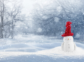 Obraz premium Cute decorative snowman in red hat outdoors on snowy day, space for text