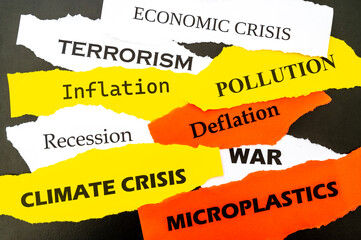 Current affairs, sheets of various colors with words: economic crisis, war, inflation, terrorism, etc., on a black background.

