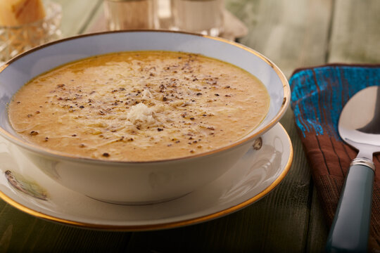 Spicy vegetable soup garnished with parmesan cheese and cracked black pepper.
