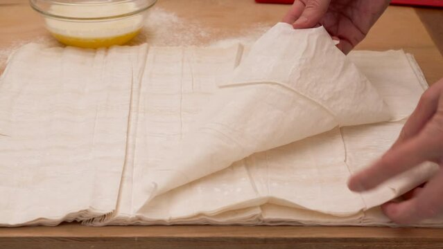 Phyllo dough and melted butter close-up on a wooden background, baking process