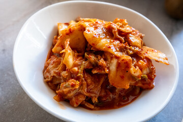 kimchi in fresh white bowl close-up on gray background
