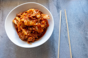 kimchi in fresh white bowl close-up on gray background
