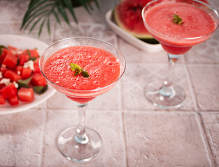Watermelon refreshing summer frozen cocktail smoothie with watermelon slices and pieces on the...