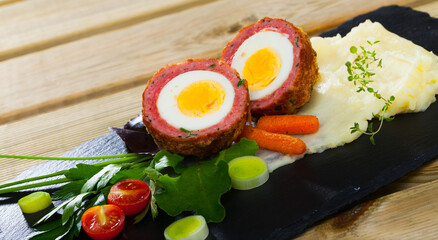 Meat stuffed eggs - Scotch egg served with potato puree and vegetables - Scottish food