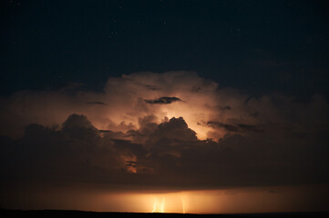 Fototapeta na wymiar lightning thunderstorm cloud flash starry sky horizon summer night