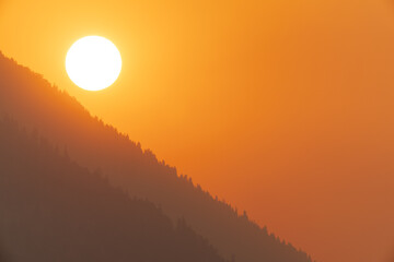 Sunrise colored gold by nearby wildfires, Eagle Nest State Lake Park, New Mexico