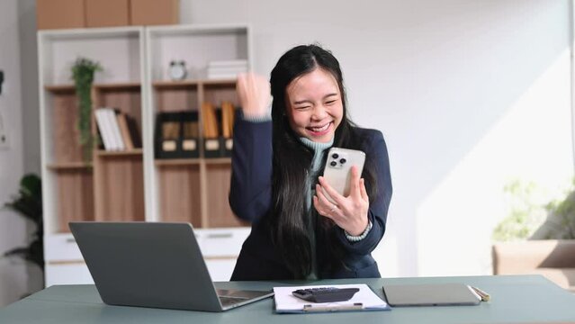 Asian female office worker business suits smiling at camera with working notepad, tablet and laptop documents . in modern office