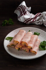 Ham and cheese rolls on a plate. Delicious appetizer meat carbonate and cream cheese.