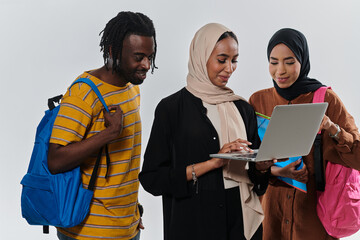 A group of students, including an African American student and two hijab-wearing women, stand...