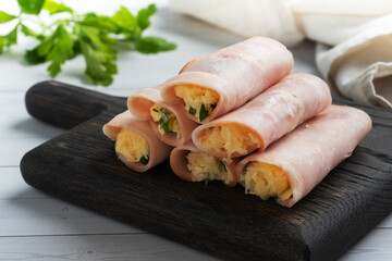 Ham and cheese rolls on a plate. Delicious appetizer meat carbonate and cream cheese.