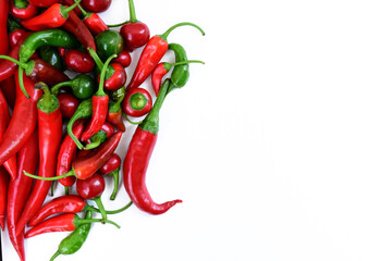 Pile of hot peppers border with space for text. Different green and red hot chili peppers frame isolated on white background