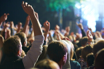 Hands, people and music festival with dancing for party at concert with stage lights, nightclub or...