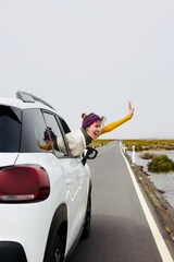 Woman in car travelling, car rental or vacation, invitation to travel