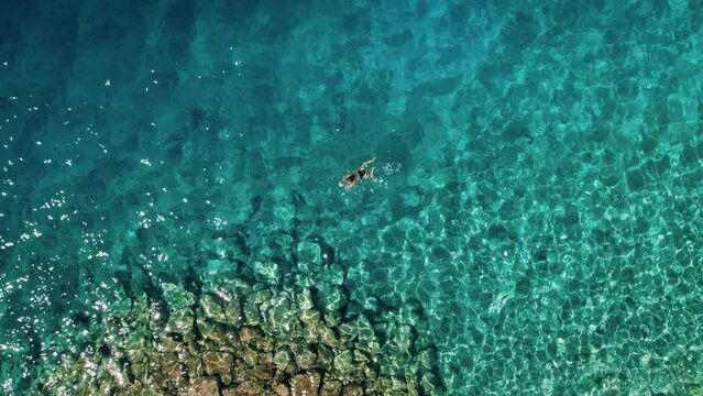 Swimming in the Adriatic Sea. A serene woman swimmer explores the vibrant underwater world of the Makarska coast in Croatia.