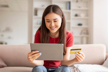 Joyful Asian Woman Using Digital Tablet And Credit Card For Online Shopping