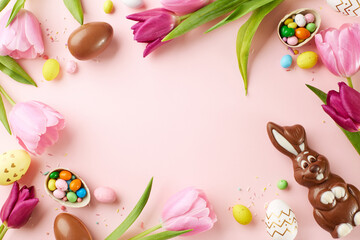 A joyful Easter greeting: overhead view of tulips, chocolate eggs, and a chocolate bunny on a pink canvas, ready to brighten greeting cards and springtime promotions