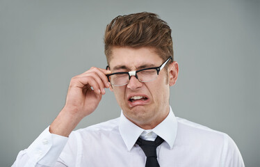 Businessman, glasses and disgust in studio for optical healthcare, omg and overwhelmed on gray backdrop. Male person, eyewear and dislike the frame choice, optometry and lens for vision support