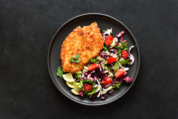 Chicken schnitzel and vegetable salad on plate