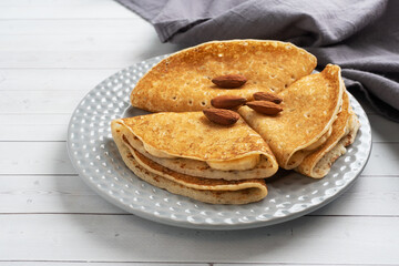 Pancakes with chocolate banana filling. Concept delicious breakfast, a white wooden table.