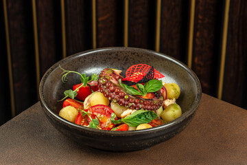 Grilled octopus tentacle with potatoes and tomatoes