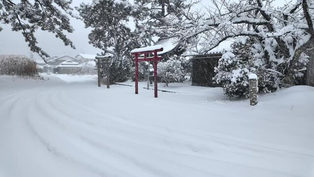 Heavy snow on torii gates at small shine in Japanese village