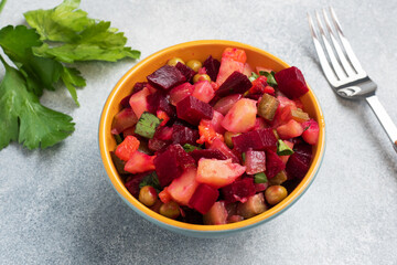 Vinaigrette with beetroot and boiled vegetables, traditional Russian homemade salad. Serving bowls with a cold snack on the table, copy space.