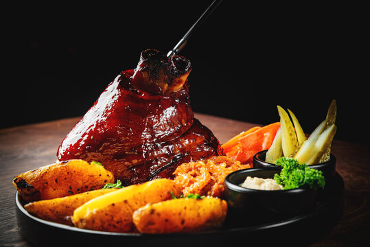 Baked Pork knuckle with vegetables on plate
