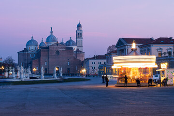 Fototapeta na wymiar Veduta serale della basilica di Santa Giustina di Padova e della antica giostra in movimento