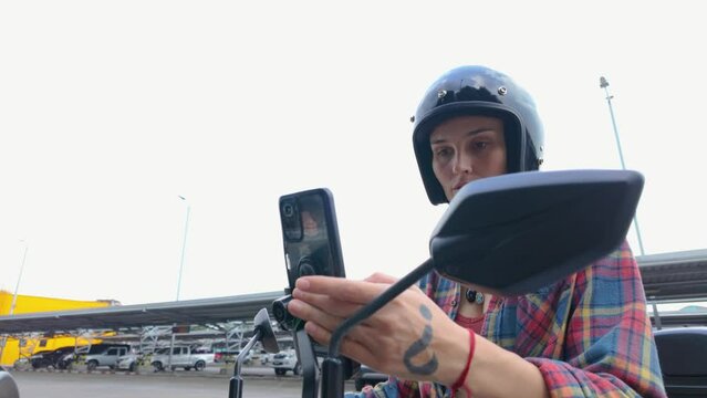 A man in a helmet is snapping a selfie on a motorbike