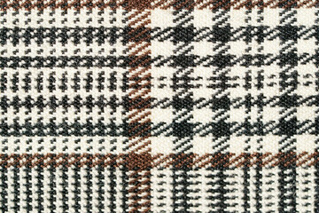 The texture of a black and brown tartan checkered fabric. Material for sewing skirts, shirts and clothes. Background for your mockup. Traditional Scottish clothing.