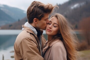 Fototapeta premium A guy kisses a girl and hugs near a lake and mountains. close-up, vertical, horizontal photo