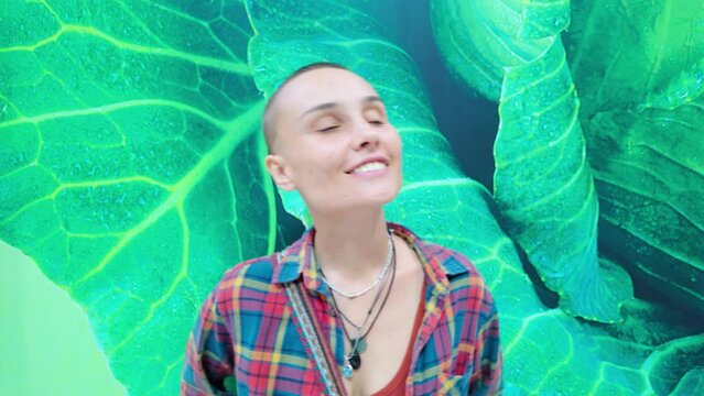 A human with a shaved head is smiling in front of a green wall
