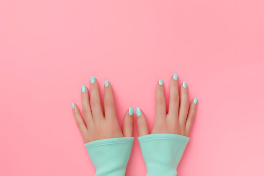 Female hands showcasing pastel stylish trendy manicure against a isolated pink background