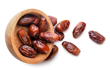 Dates fruits spilled out from a wooden plate on a white background. Top view