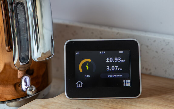 Remote smart meter display showing electricity used in British pounds and kilowatt when kettle switched on.