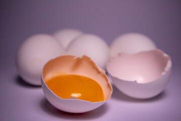 Close-up photo of white eggs on a pink background, egg yolk in shell