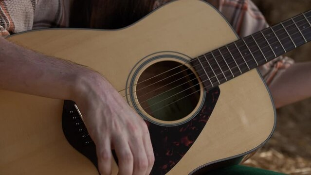 Close-up of the deck and resonator of a classical guitar played by a musician 