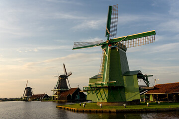 Fototapeta na wymiar Windmills in the beautiful village of Zaanse Schans in Netherlands at sunset