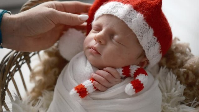 Solicitous Mother Softly Stroking Her Newborn Baby Boy In Santa Hat, Christmas Holidays