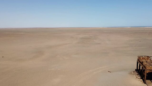 Skeleton Coast National Park, Namibia - August 21, 2022: Drone footage of the remnants of a rusted old oil rig tower, destroyed by the Benguela current