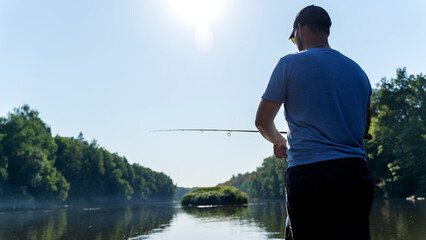 A fisherman is fishing for spinning from a boat