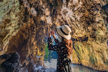 Asian women tourist lifts camera to take a photo inside Tham Lod cave Pai, Maehongson, Tham Lod Cave one of the most amazing cave in Thailand. - 735139521
