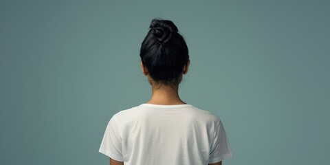 A woman holding a toothbrush while wearing a white shirt. Ideal for dental hygiene and personal care concepts