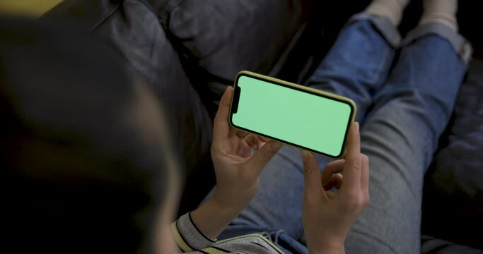 Close up shot of a woman using a smart phone with green screen