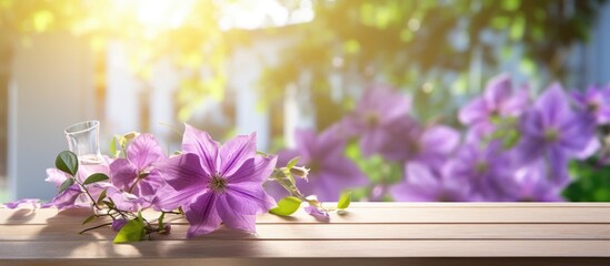 Natural summertime cooking template fresh green leaves and violet flowers of clematis over an empty empty table with violet checkered tablecloth on a sunny day with copy space. Creative Banner