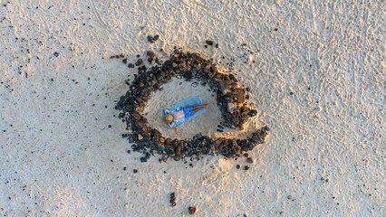 Aerial view from flying drone of a tourist crowd relaxing on the beach inside the traditional Stone wind shelter in Fuerteventura, Canary Island. Spain